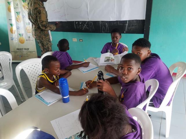 Young people in Project GOLD purple uniforms studying together