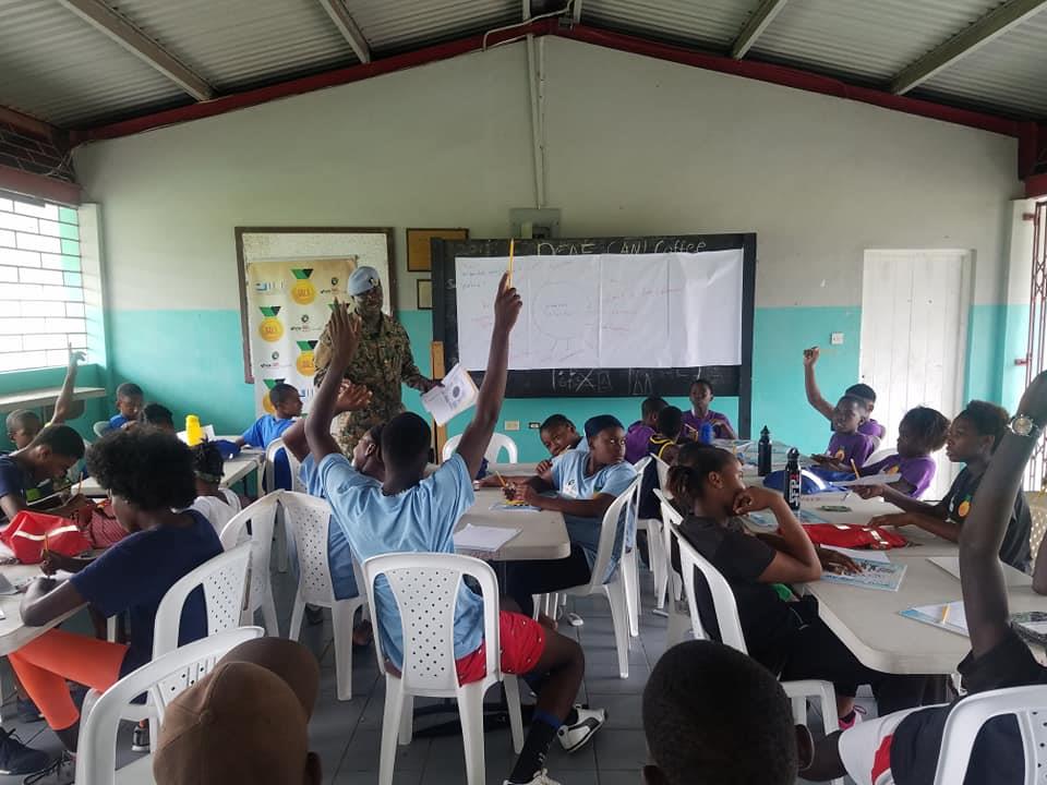 Project GOLD classroom session with hands raised